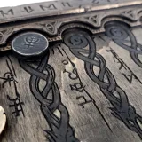 Engraved rune checkers in the storage tray of the backgammon board